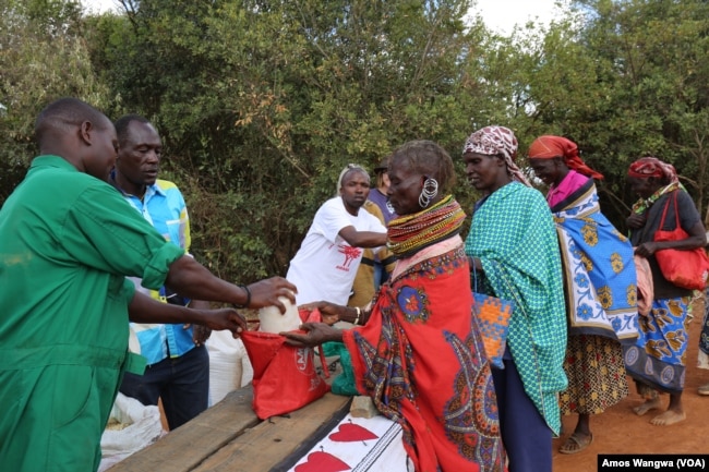 Village women collect food donations from the Laikipia Nature Conservancy in Kenya, where owner Kuki Gallmann distributes staple foods and water to help her neighbors get through the drought, March 19, 2017. (J. Craig/VOA)