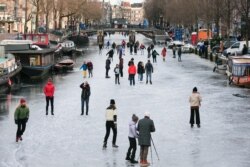 People ice skate during a cold snap across the country at the Prinsengracht in Amsterdam, Netherlands February 14, 2021. (REUTERS/Eva Plevier)