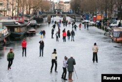 People ice skate during a cold snap across the country at the Prinsengracht in Amsterdam, Netherlands February 14, 2021. (REUTERS/Eva Plevier)