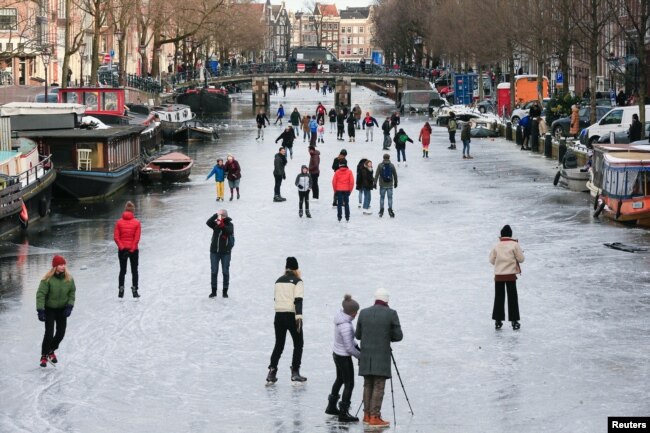 People ice skate during a cold snap across the ｃountry at the Prinsengracht in Amsterdam, Netherlands February 14, 2021. (REUTERS/Eva Plevier)
