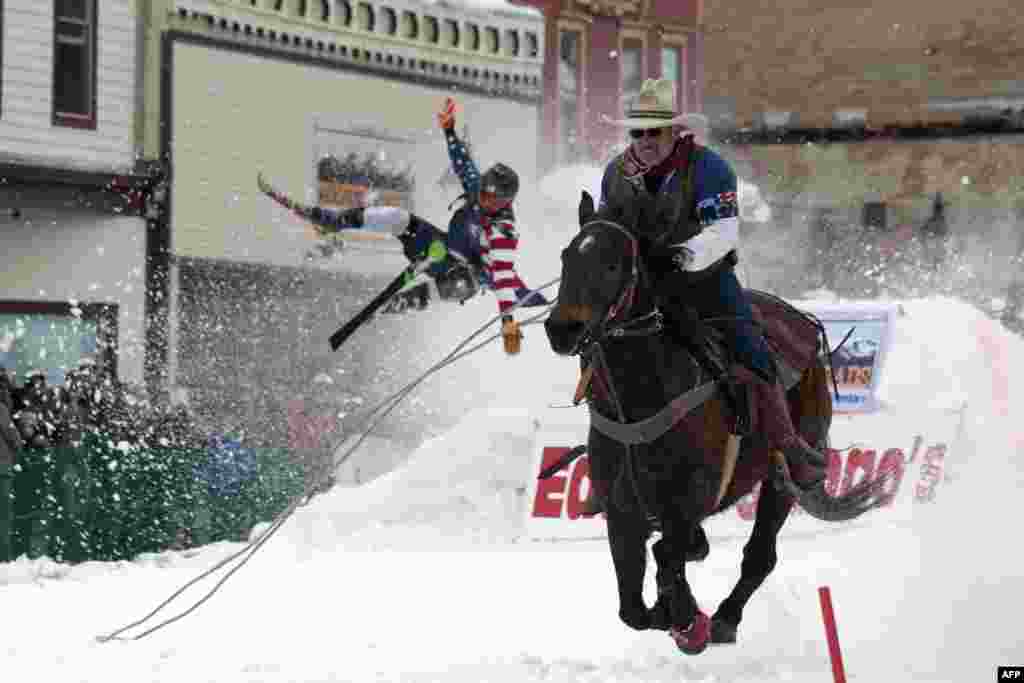 Jeff Dahl races down Harrison Avenue while skier Vincent Pestello looses control of the first jump of the Leadville ski joring course during the 71st annual Leadville Ski Joring weekend competition, March 2, 2019 in Leadville, Colorado.
