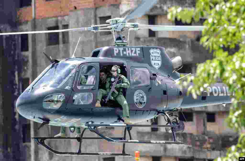 Marcelo Pinheiro, aka "Piloto," the leader of Brazilian criminal gang Comando Vermelho, (2nd-R), is escorted in a Parana state police helicopter, on their way to Catanduvas maximum security federal penitentiary in Parana state, Brazil, after leaving the city of Foz do Iguacu, Nov. 19, 2018.