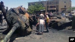 An image from Edlib News Network shows citizens looking at a Syrian tank destroyed during clashes between rebels and Syrian government forces in Idlib province, June 4, 2012. (The photo cannot be independently confirmed)