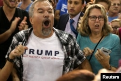 FILE - A Donald Trump supporter heckles U.S. Democratic presidential nominee Hillary Clinton and former Vice President Al Gore as they talk about climate change at a rally at Miami Dade College in Miami, Fla., Oct. 11, 2016.
