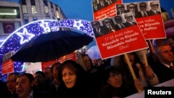 Supporters of main opposition Republican People's Party (CHP) hold placards with pictures of four former ministers while shouting anti-government slogans during a protest in Istanbul, Turkey, Dec. 17, 2014.