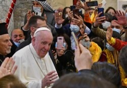 Paus Fransiskus disambut oleh orang-orang saat ia tiba di Gereja Katolik Suriah yang Dikandung Tanpa Noda (al-Tahira-l-Kubra), di kota Qaraqosh (Baghdeda) yang mayoritas beragama Kristen. (Foto: AFP)