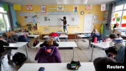  A teacher, wearing a protective face mask, teaches to schoolchildren in a classroom at a private school during its reopening in Saint-Sebastien-sur-Loire near Nantes