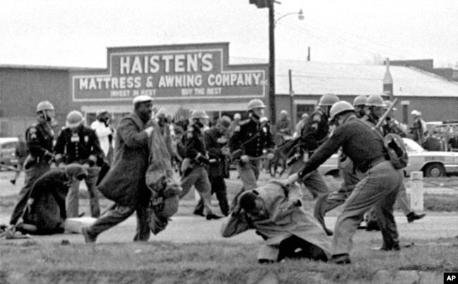 FILE - Alabama state troopers use clubs against voting rights marchers in Selma on March 7, 1965. At foreground right, John Lewis, chairman of the Student Nonviolent Coordinating Committee, is beaten. (Associated Press)