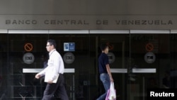 Personas pasan frente a la entrada del Banco Central de Venezuela, en Caracas, el 1 de diciembre de 2017. Reuters/Marco Bello.