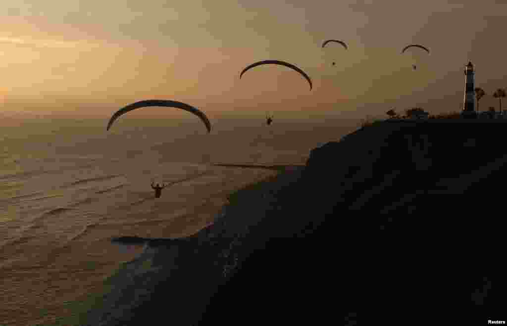 Paragliders fly in front of Lima&#39;s Miraflores district, Peru, Nov. 20, 2013. 