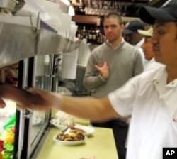 2nd Avenue Deli owner Jeremy Liebewohl behind the counter surveying his domain.