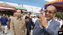 Phnom Penh Governor Kep Chuktema, right, greets well-wishers as he arrives for the inauguration ceremony of Democracy Square in downtown Phnom Penh.