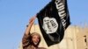 A militant Islamist fighter waving a flag, cheers as he takes part in a military parade along the streets of Syria's northern Raqqa province, June 30, 2014. 