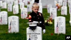 Christian Jacobs (5 tahun) dari Hertford, N.C., berpakaian seperti Marinir, memberi penghormatan di hadapan nisan ayahnya pada Hari Pahlawan (Memorial Day) di Arlington National Cemetery, Arlington, VA, Senin 30 Mei 2016. (Foto: dok).