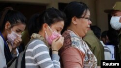 A relative (R) of a victim of a plane crash arrives to a building of a Chinese temple, which is functioning as a temporary mortuary, in Pakse on October 19, 2013.