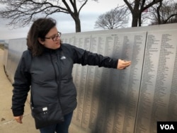 Erin Josen points to the name of a great-grandparent who immigrated to the U.S., inscribed on Ellis Island's American Immigrant Wall of Honor. (R. Taylor/VOA)