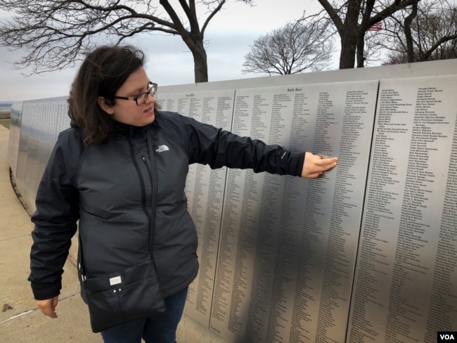 Erin Josen points to the name of a great-grandparent who immigrated to the U.S., inscribed on Ellis Island's American Immigrant Wall of Honor. (R. Taylor/VOA)