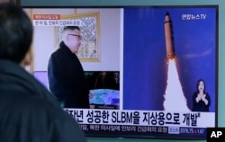 FILE - A man watches a TV news program showing photos published in North Korea's Rodong Sinmun newspaper of North Korea's Pukguksong-2 missile launch and North Korean leader Kim Jong Un at Seoul Railway Station in Seoul, South Korea, Feb. 13, 2017.