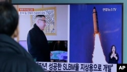 FILE - A man watches a TV news program showing photos published in North Korea's Rodong Sinmun newspaper of North Korea's "Pukguksong-2" missile launch and North Korean leader Kim Jong Un at Seoul Railway Station in Seoul, South Korea, Feb. 13, 2017.