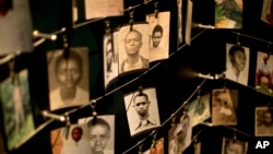 FILE - Family photographs of some of those who died in the Rwandan genocide hang in a display in a memorial center in Kigali, Rwanda, April 5, 2014.