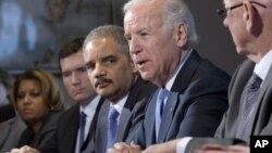 El vicepresidente Joe Biden es acompañado por el Fiscal General, Eric Holder, durante una reunión con grupos de víctimas y defensores del control de armas.