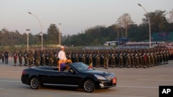 Myanmar's President Thein Sein, standing in an open vehicle, inspect officers and soldiers during a ceremony to mark the 67th anniversary of Independence Day in Naypyitaw, Jan. 4, 2015. 