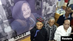 FILE - Three women who said they were forced to become comfort women by the Japanese military during World War II, attend the opening ceremony of the Chinese "Comfort Women" Archives at Shanghai Normal University.