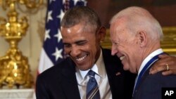 FILE - President Barack Obama laughs with Vice President Joe Biden during a ceremony in the State Dining Room of the White House in Washington, Jan. 12, 2017.