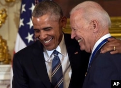 FILE - President Barack Obama laughs with Vice President Joe Biden during a ceremony in the State Dining Room of the White House in Washington, Jan. 12, 2017.