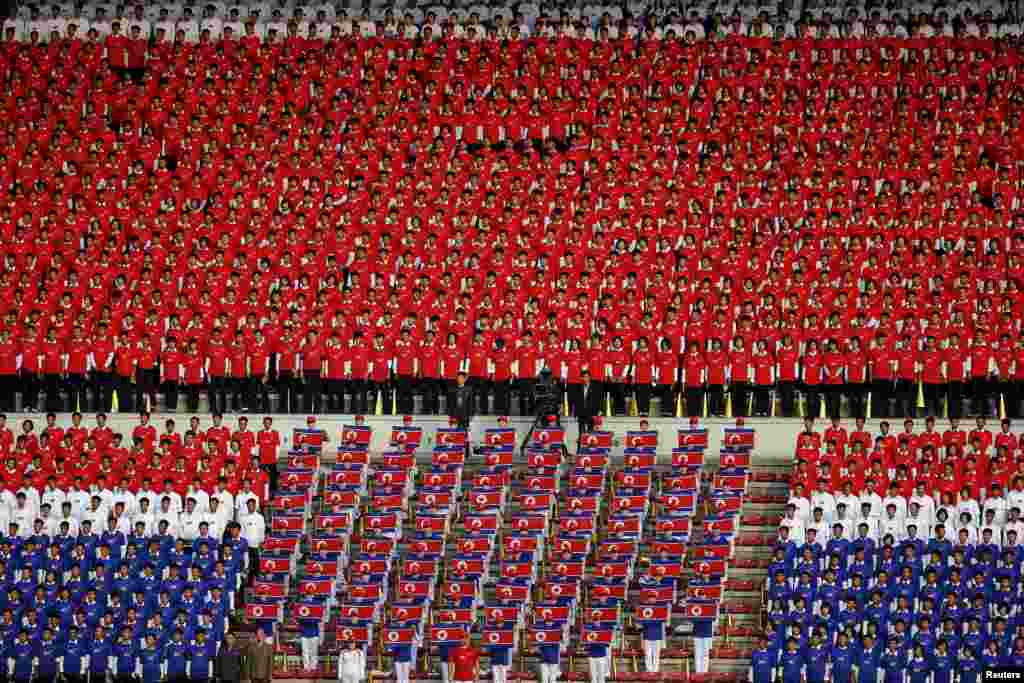 Người dân Bắc Triều Tiên trong trang phục màu cờ của đất nước hát quốc ca trước trận vòng loại của giải World Cup 2018 và AFC Asian Cup 2019 giữa đội nhà với đội Philippines tại sân vận động Kim Il Sung ở Bình Nhưỡng.