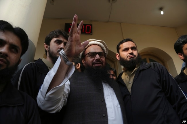 FILE - Hafiz Saeed, head of the Pakistan's Jamaat-ud-Dawa group, waves to supporters at a mosque in Lahore, Pakistan, Nov. 24, 2017.