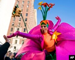 A participant in the Macy's Thanksgiving Day Parade touches hands with a spectator along Central Park West in New York, Nov. 23, 2017.