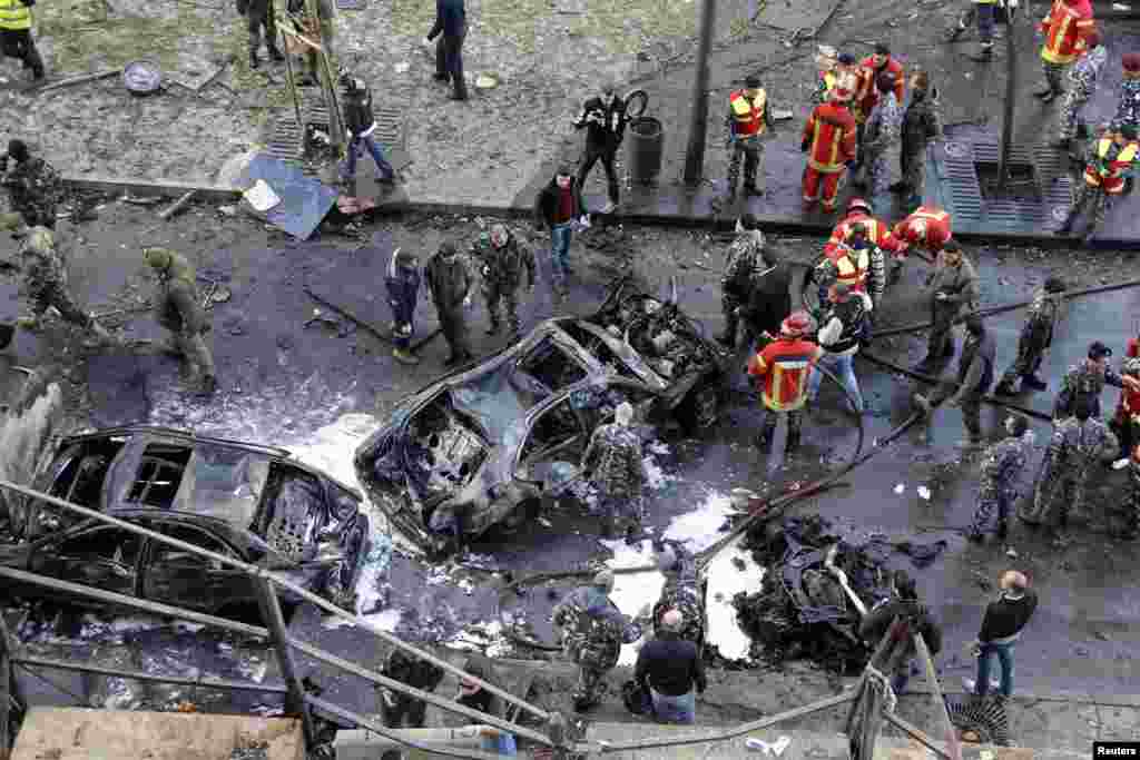 Civis, soldados e agentes da polícia reunidos no local da explosão na Baixa de Beirute, Líbano, Dez. 27, 2013, que matou o ex ministro das finanças Mohamad Chata. 