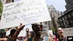 Brigid Turner, a Jamaican national who lives in Brooklyn, holds a sign while chanting during a rally in front of the Nigerian consulate, May 10, 2014, in New York.