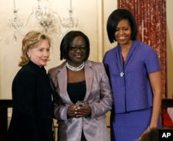 FILE - First lady Michelle Obama and Secretary of State Hillary Rodham Clinton present the 2010 International Women of Courage Award to Jestina Mukoko of Zimbabwe on March 10, 2010, at the State Department in Washington.