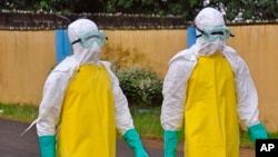 西非搬運死於伊波拉病毒屍體的工作人員﹐全身穿著保護衣物以免感染。