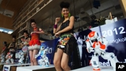 FILE - Humanoid robots called Nao, developed by a French company, Aldebaran Robotics, dance along with models to mark the opening of a press conference of the Manufacturing Expo in Bangkok, June 19, 2012.
