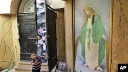Children run past a painting of Mariam Al-Adra (Virgin Mary) inside the entrance of the Virgin Mary Coptic church in the al-Asafra area of the coastal city of Alexandria, Egypt (July 2010 file photo)