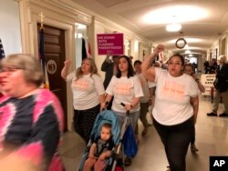 Protesters march through the halls of the Missouri Capitol, outside the House chamber, May 17, 2019, in Jefferson City, in opposition to legislation prohibiting abortions after the eighth week of pregnancy.