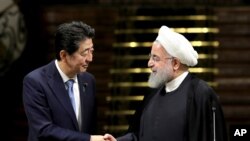  Japanese Prime Minister Shinzo Abe, left, and Iranian President Hassan Rouhani shake hands after their joint press conference at the Saadabad Palace in Tehran, Iran, June 12, 2019. 