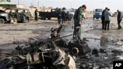 Iraqi security forces inspect the scene of a car bomb attack in Ramadi, 70 miles (115 kilometers) west of Baghdad, Iraq, 12 Dec 2010