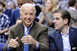 FILE - Then-Vice President Joe Biden and his son Hunter are pictured at a college basketball game in Washington, Jan. 30, 2010.