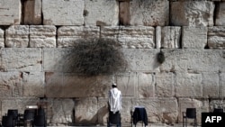 FILE - A Jewish man prays at the Western Wall, Judaism's most holy site, in Jerusalem's Old City. Israel objects to a UNESCO draft resolution it says ignores the religion's historic ties to such sites.