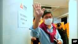 Chris Yeung, founder and chief writer of Citizen News waves to journalists after a press conference outside his office in Hong Kong Monday, Jan. 3, 2022. (AP Photo/Vincent Yu)