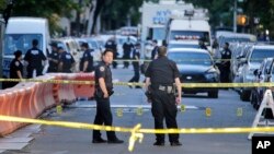 Les policiers cadrillent la rue où un policier a été abattu dans la section Bronx de New York, le mercredi 5 juillet 2017.