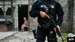 Una anciana mira a un policía ecuatoriano que participa en una operación conjunta de seguridad con las fuerzas armadas en Durán, Ecuador, el 24 de octubre de 2024. 