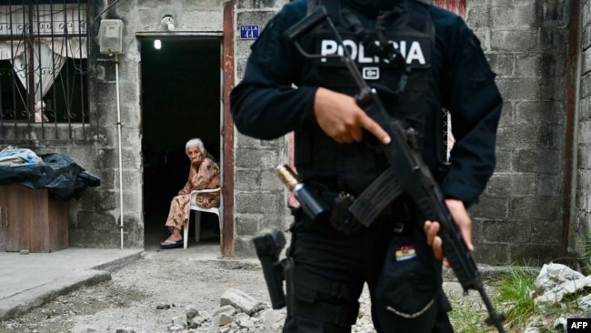 Una anciana mira a un policía ecuatoriano que participa en una operación conjunta de seguridad con las fuerzas armadas en Durán, Ecuador, el 24 de octubre de 2024. 