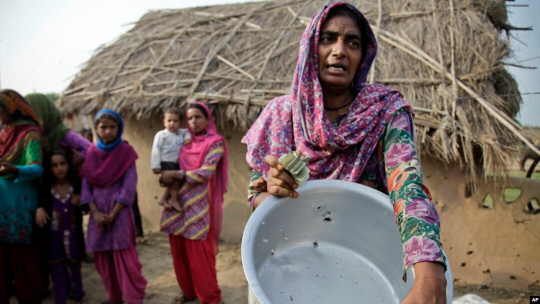 Người dân cho thấy 1 thùng nước bị hư hỏng do súng đạn được cho là từ phía Pakistan, ở làng Jora Farm trong khu vực Ranbir Singh Pura của Ấn Độ, 23/8/2014.