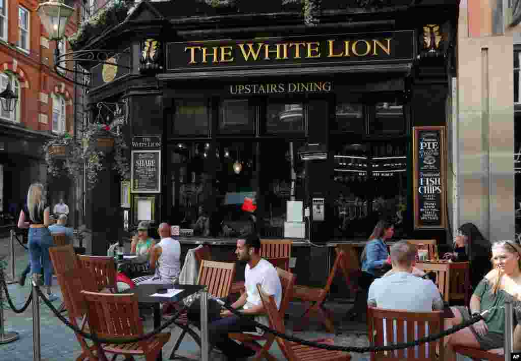 گروهی از مردم در لندن در بیرون رستوران‌ها نشسته‌اند. بریتانیا برای جلوگیری از موج جدید کرونا در برخی نقاط سختگیری‌هایی اعمال کرده و نخست وزیر این کشور توصیه کرده همه تا حد امکان از خانه کار کنند. 
