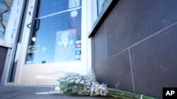 Bouquets of flowers are placed outside the door of a tattoo parlor along South Broadway on Dec. 28, 2021 in Denver, one of the scenes of a shooting spree that left five people dead - including the suspected shooter Monday evening.